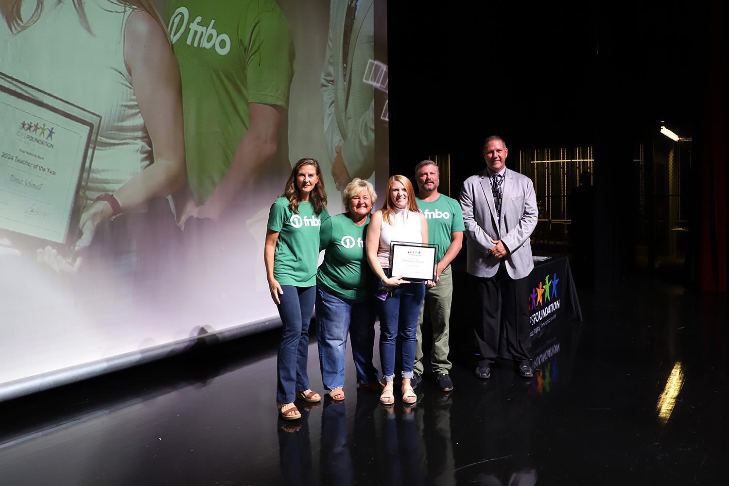 Tonia Schmall accepting her Teacher of the Year Award on stage at GIPS Welcome back.